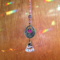 With a nod to bright tones and textures, this one of a kind large crystal sun catcher hanging, holds a gorgeous shape and design featuring a 60mm faceted crystal prism (epic rainbow maker) with unique gemstones. An exceptional piece and quite lovely when hung.  Finished with a sturdy chain and solid  hook for easy hanging.