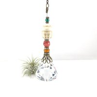 This charming handmade crystal hanging will adorn any room with rainbows and lively reflections, making it a delightful addition for yourself or a thoughtful gift that will be treasured.Featuring a high-quality, medium (40mm) faceted crystal prism, meticulously hand-strung with Howlite gemstone Buddha Focal, Cherry Quartz and distinctive Czech glass beads. It is completed with chain and hook, ensuring effortless hanging and allowing gentle movement that makes the rainbows dance.