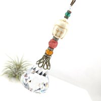 This charming handmade crystal hanging will adorn any room with rainbows and lively reflections, making it a delightful addition for yourself or a thoughtful gift that will be treasured.Featuring a high-quality, medium (40mm) faceted crystal prism, meticulously hand-strung with Howlite gemstone Buddha Focal, Cherry Quartz and distinctive Czech glass beads. It is completed with chain and hook, ensuring effortless hanging and allowing gentle movement that makes the rainbows dance.