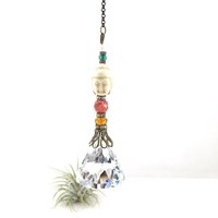 This charming handmade crystal hanging will adorn any room with rainbows and lively reflections, making it a delightful addition for yourself or a thoughtful gift that will be treasured.Featuring a high-quality, medium (40mm) faceted crystal prism, meticulously hand-strung with Howlite gemstone Buddha Focal, Cherry Quartz and distinctive Czech glass beads. It is completed with chain and hook, ensuring effortless hanging and allowing gentle movement that makes the rainbows dance.