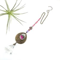 With a nod to bright tones and textures, this one of a kind large crystal sun catcher hanging, holds a gorgeous shape and design featuring a 60mm faceted crystal prism (epic rainbow maker) with unique gemstones. An exceptional piece and quite lovely when hung.  Finished with a sturdy chain and solid  hook for easy hanging.
