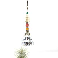 This charming handmade crystal hanging will adorn any room with rainbows and lively reflections, making it a delightful addition for yourself or a thoughtful gift that will be treasured.Featuring a high-quality, medium (40mm) faceted crystal prism, meticulously hand-strung with Howlite gemstone Buddha Focal, Cherry Quartz and distinctive Czech glass beads. It is completed with chain and hook, ensuring effortless hanging and allowing gentle movement that makes the rainbows dance.