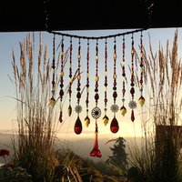 Adorn your personal space with our unique, exceptional chandelier beaded curtain or what we lovingly refer to as a "Window Necklace".  The fluid nature (similar to a necklace) of this eleven strand hanging, allows for gentle movement after being hung which creates wonderful and beautiful reflections with just about any light and atmosphere.

Vintage Murano chandelier focal, new and vintage chandelier prism, and stamped Strass Swarovski crystal. Beads: Ruby, Swarovski, and Czech glass beads.