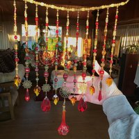 Adorn your personal space with our unique, exceptional chandelier beaded curtain or what we lovingly refer to as a "Window Necklace".  The fluid nature (similar to a necklace) of this eleven strand hanging, allows for gentle movement after being hung which creates wonderful and beautiful reflections with just about any light and atmosphere.

Vintage Murano chandelier focal, new and vintage chandelier prism, and stamped Strass Swarovski crystal. Beads: Ruby, Swarovski, and Czech glass beads.