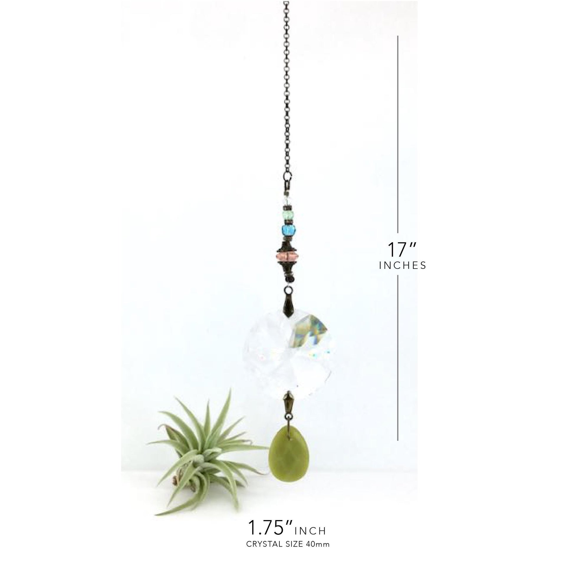 This charming bohemian inspired crystal sun catcher hanging with Jade gemstone drop is a minimalist style hanging. The prism focal is a high-quality Asfour 40mm crystal, renowned for casting rainbows and reflections that dance across the room. Beautiful faceted Jade gemstone drop, thoughtfully strung together with vintage Czech glass beadsand finished with a versatile chain for easy hanging in a variety of spaces, from your car's rearview mirror to a cozy corner of your home.