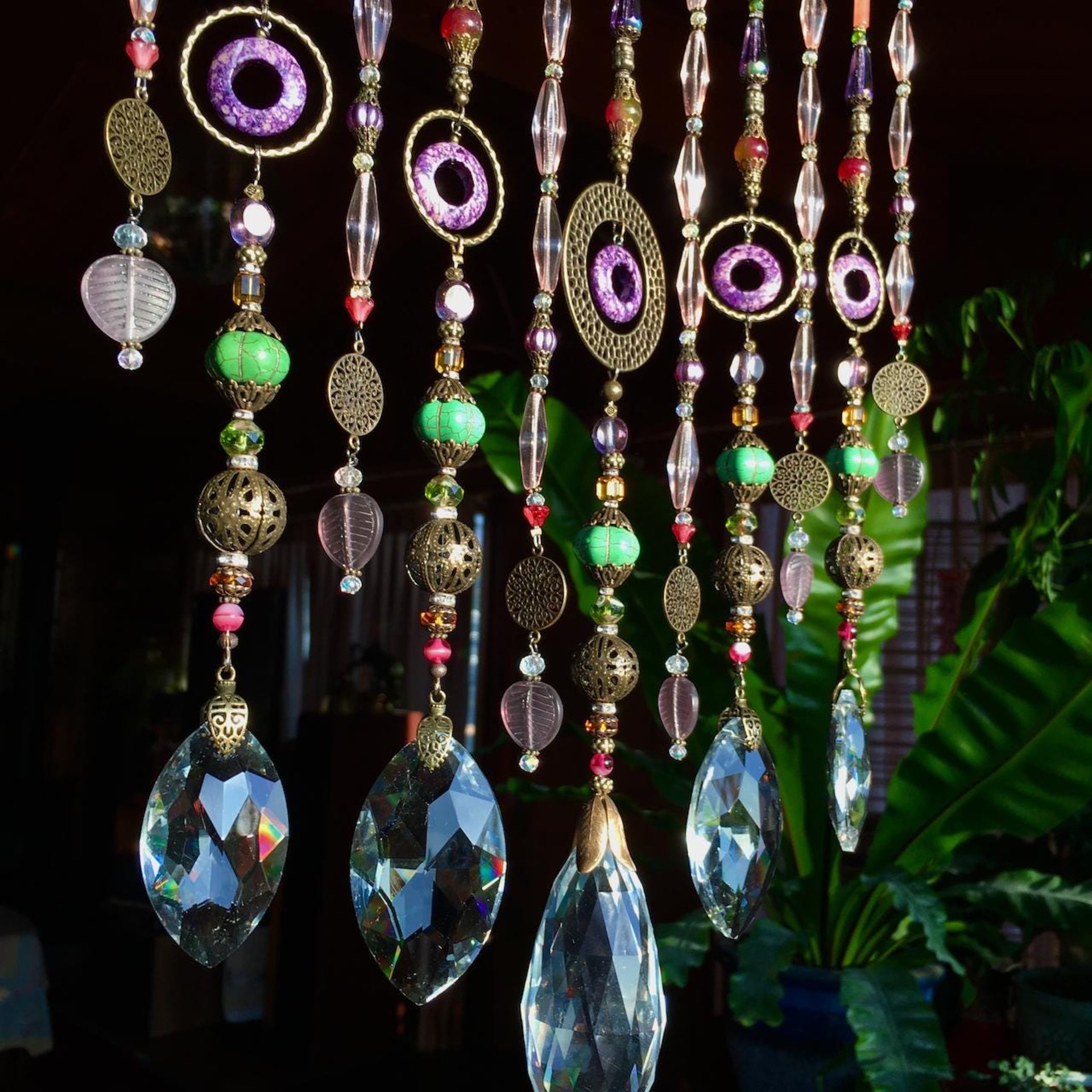 Adorn your personal space with our unique, exceptional chandelier beaded curtain or what we lovingly refer to as a "Window Necklace".  The fluid nature (similar to a necklace) of this eleven strand hanging, allows for gentle movement after being hung which creates wonderful and beautiful reflections with just about any light and atmosphere.Chandelier crystal prisms, creating epic rainbows! Gemstones and Crystal include: Malaysian Jade, Howlite, Purple Lace Agate, vintage and new Czech glass.