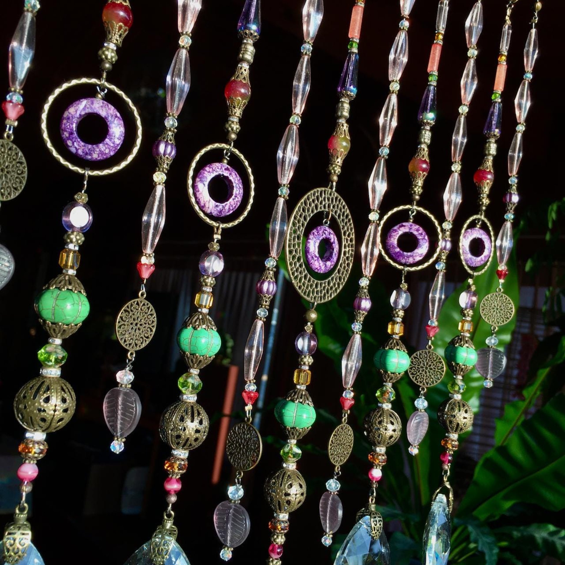 Adorn your personal space with our unique, exceptional chandelier beaded curtain or what we lovingly refer to as a "Window Necklace".  The fluid nature (similar to a necklace) of this eleven strand hanging, allows for gentle movement after being hung which creates wonderful and beautiful reflections with just about any light and atmosphere.Chandelier crystal prisms, creating epic rainbows! Gemstones and Crystal include: Malaysian Jade, Howlite, Purple Lace Agate, vintage and new Czech glass.