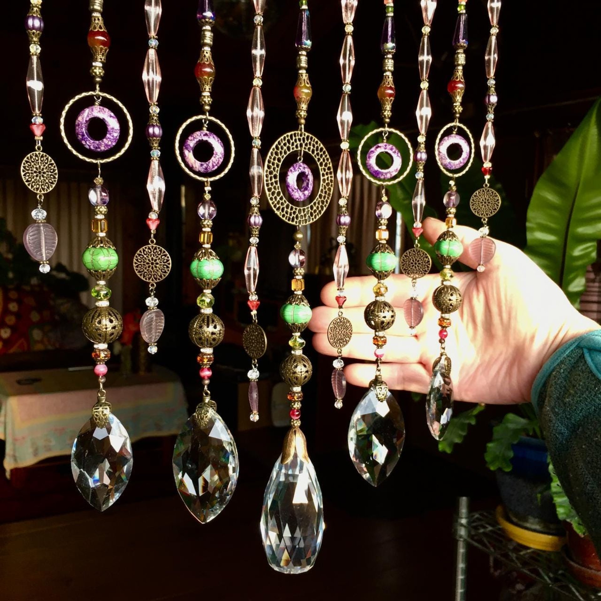 Adorn your personal space with our unique, exceptional chandelier beaded curtain or what we lovingly refer to as a "Window Necklace".  The fluid nature (similar to a necklace) of this eleven strand hanging, allows for gentle movement after being hung which creates wonderful and beautiful reflections with just about any light and atmosphere.Chandelier crystal prisms, creating epic rainbows! Gemstones and Crystal include: Malaysian Jade, Howlite, Purple Lace Agate, vintage and new Czech glass.