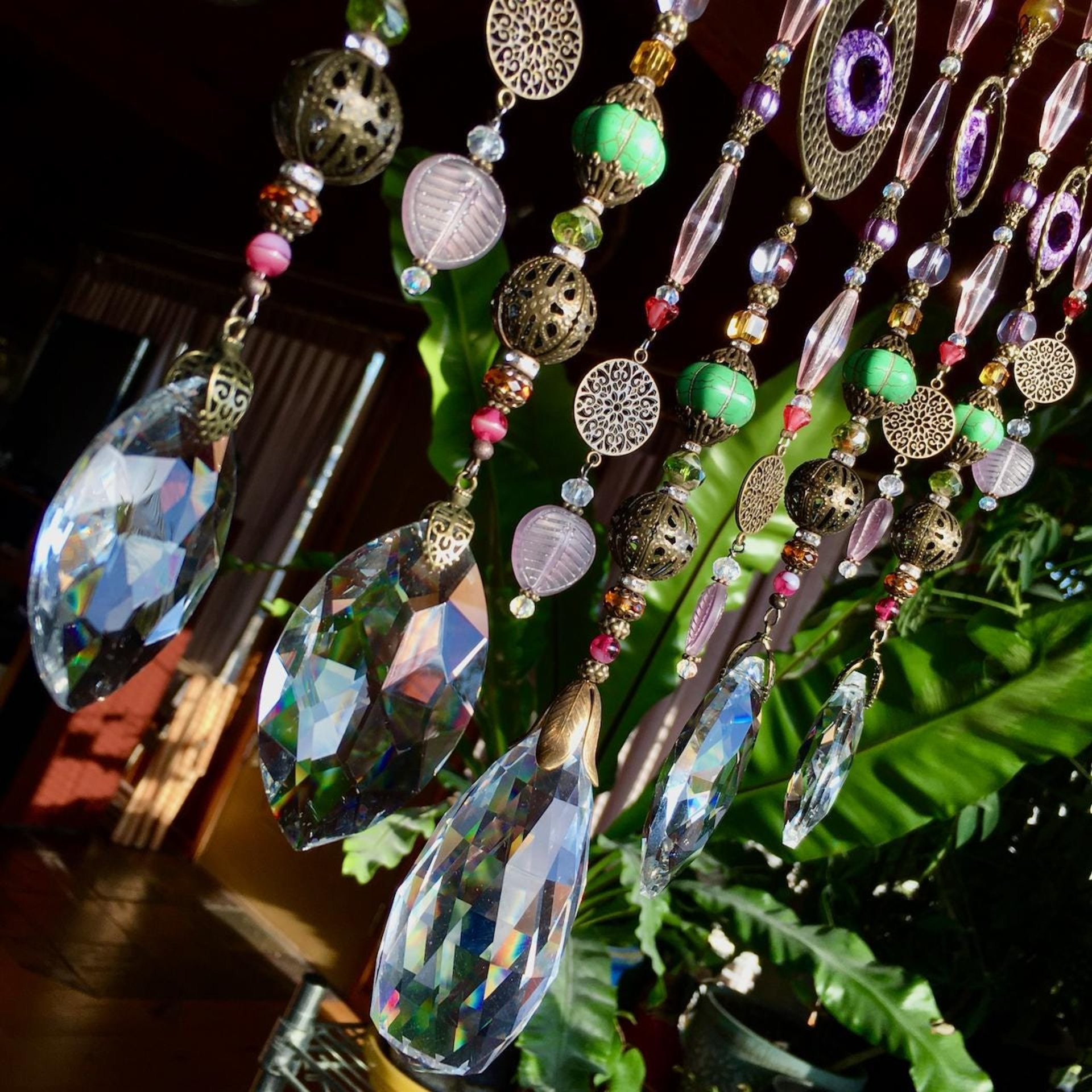 Adorn your personal space with our unique, exceptional chandelier beaded curtain or what we lovingly refer to as a "Window Necklace".  The fluid nature (similar to a necklace) of this eleven strand hanging, allows for gentle movement after being hung which creates wonderful and beautiful reflections with just about any light and atmosphere.Chandelier crystal prisms, creating epic rainbows! Gemstones and Crystal include: Malaysian Jade, Howlite, Purple Lace Agate, vintage and new Czech glass.