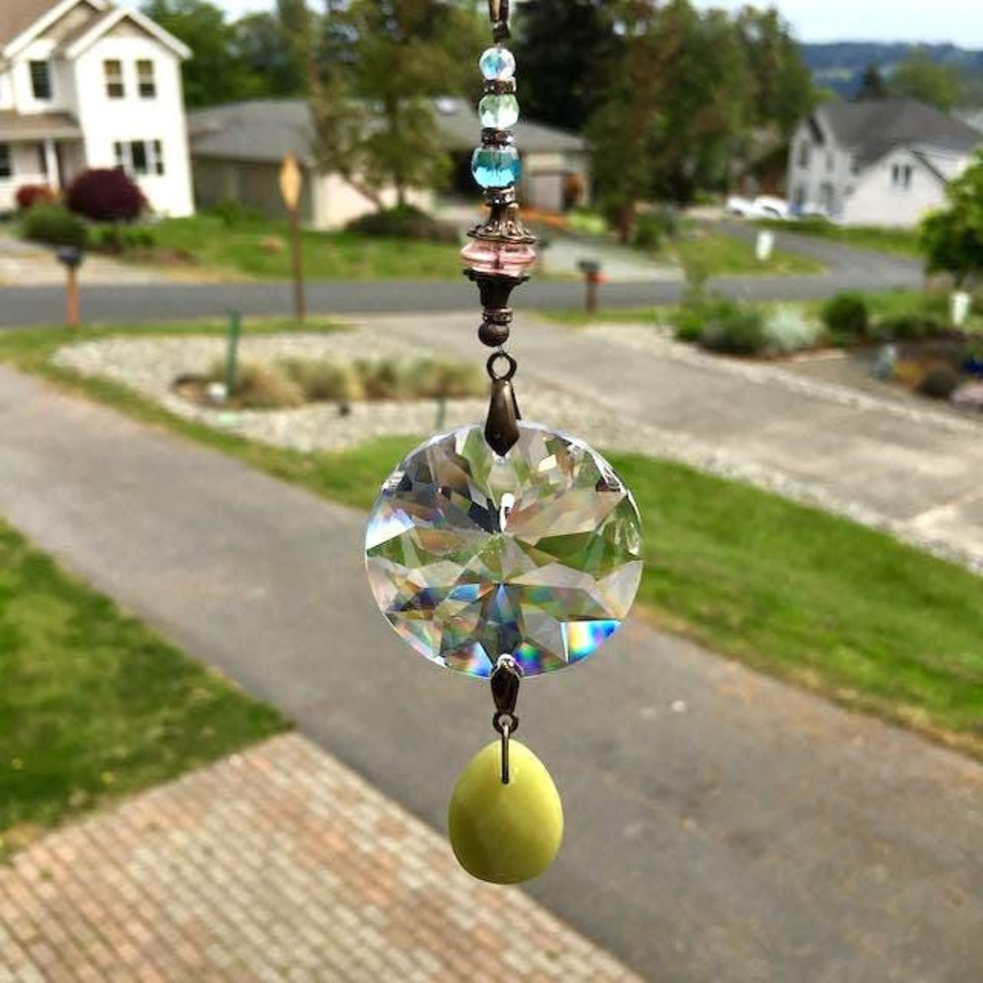This charming bohemian inspired crystal sun catcher hanging with Jade gemstone drop is a minimalist style hanging. The prism focal is a high-quality Asfour 40mm crystal, renowned for casting rainbows and reflections that dance across the room. Beautiful faceted Jade gemstone drop, thoughtfully strung together with vintage Czech glass beadsand finished with a versatile chain for easy hanging in a variety of spaces, from your car's rearview mirror to a cozy corner of your home.
